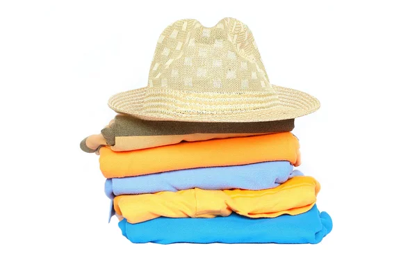 Σωρό από πολύχρωμα ρούχα με ένα καπέλο πάνω από το λευκό φόντο — Φωτογραφία Αρχείου
