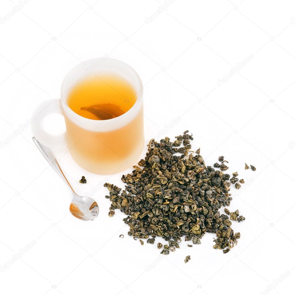 Green tea leaves with cup of tea and silver spoon isolated on wh