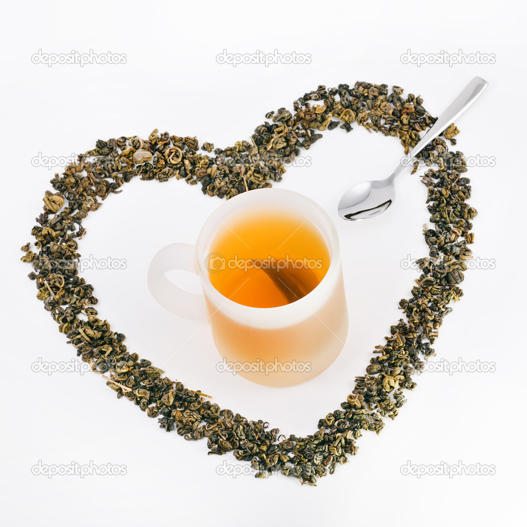 Cup of green tea, green tea leaves in shape of heart