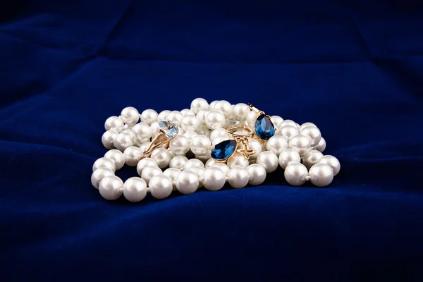 Takı. inci boncuk, mavi küpe ve bir altın yüzük ile topaz