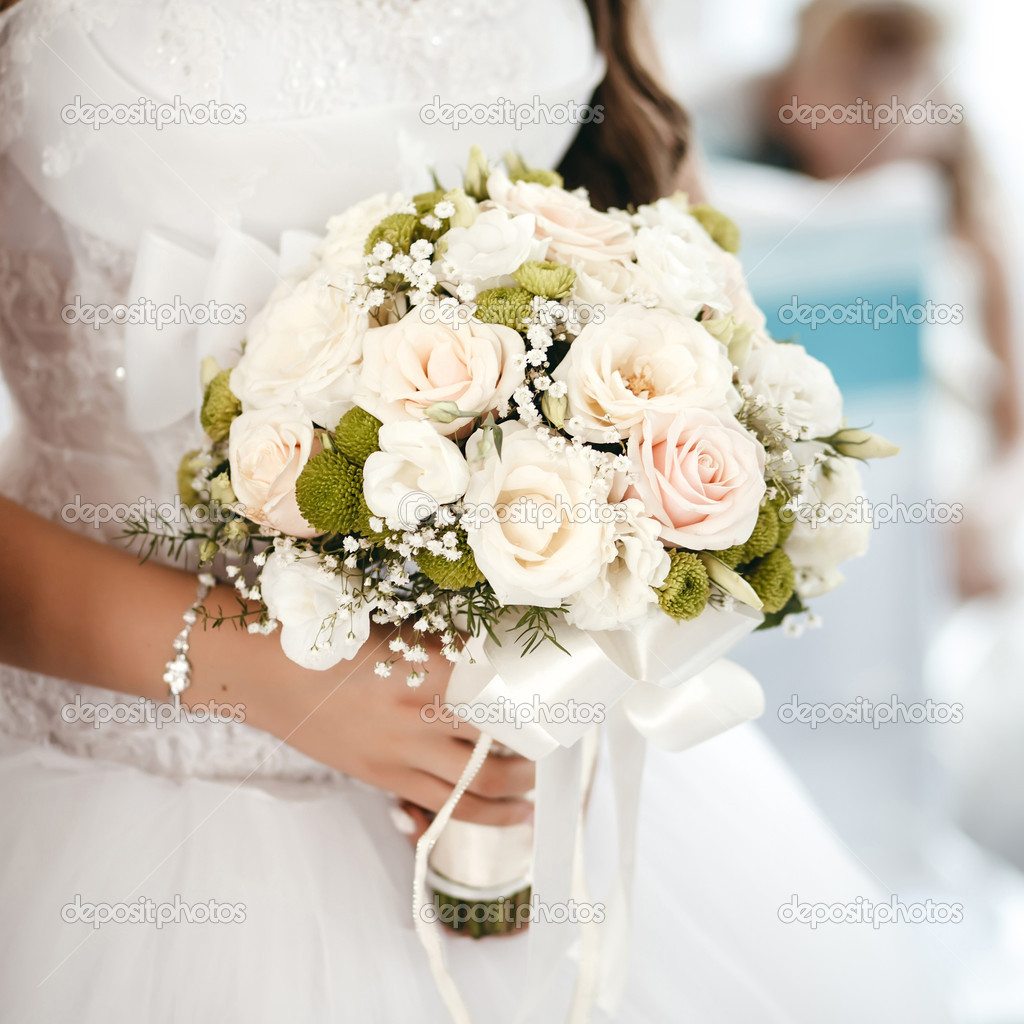 Bride holding wedding bouquet from roses at a wedding ceremony