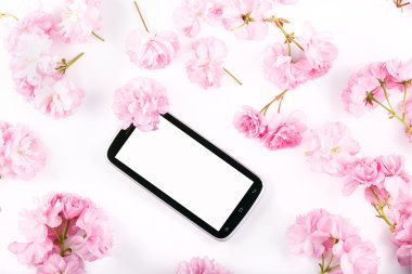 pembe kiraz çiçekleri tarafından çevrili mobil akıllı telefon