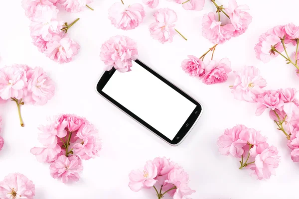 Mobil teléfono inteligente rodeado de flores de cerezo rosa — Foto de Stock