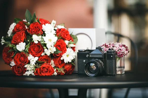 Composición de ramo con rosas rojas y manzanilla y cámara — Foto de Stock