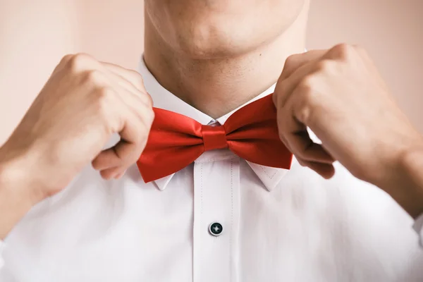 Man puts on red bow tie. Close up. Shallow depth of field. — Stock Photo, Image