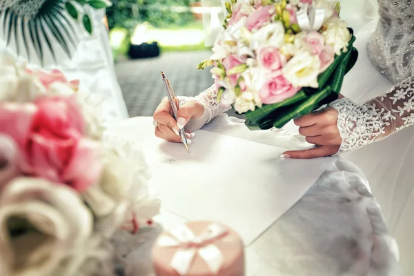 Braut unterzeichnet Dokument über standesamtliche Trauung. Stockbild