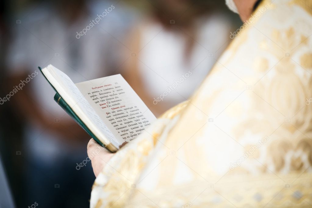 Priest read prayer-book. Shallow depth of field.