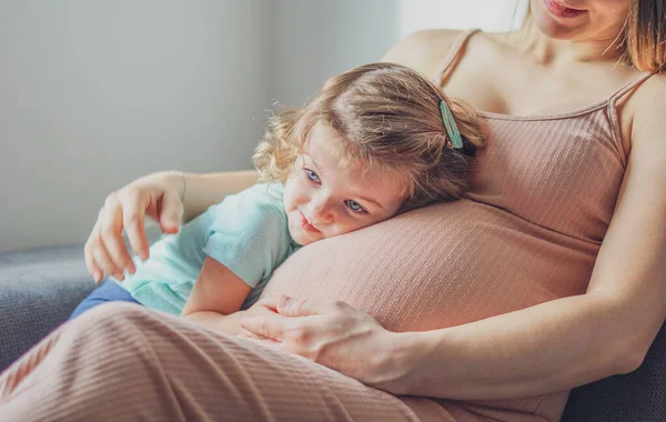 小さな赤ちゃんの女の子は母親の妊娠中の腹でリラックス 幼児と妊婦 ファミリーコンセプト — ストック写真