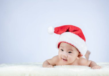 Noel Baba şapkası takan şirin bir bebeğin Noel portresi..