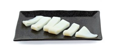 Taş tabaktaki çiğ mürekkep balığı beyaz arka planda izole edilmiş, shabu, sıcak çömlek malzemeleri..