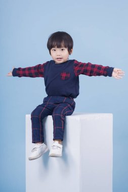 Mavi arka planda sevimli bir çocuğun portresi.