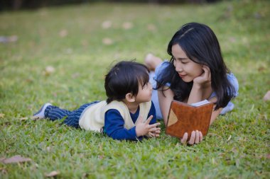 Anne ve oğlu bir kitap birlikte parkta okumak