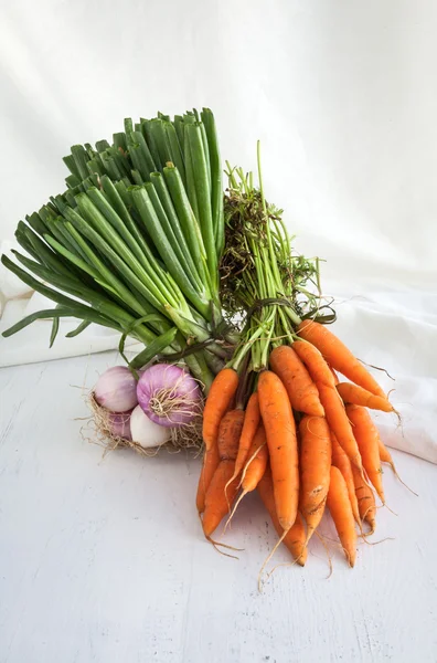 Морковь на деревянном фоне и белой ткани — стоковое фото