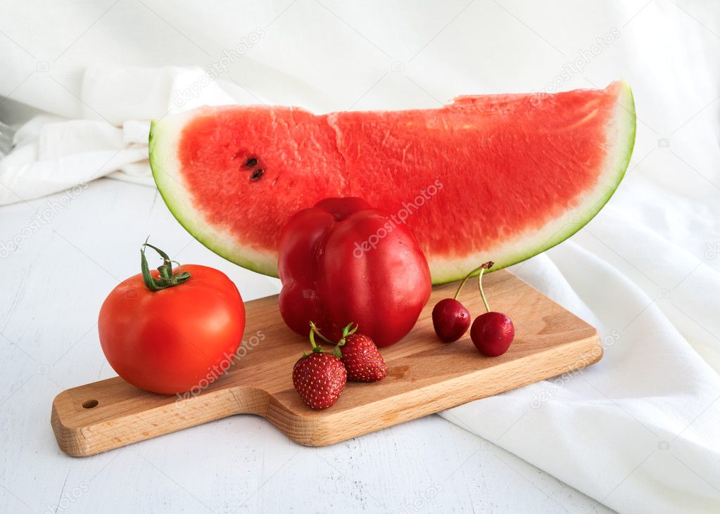 Water melon, tomatoes, strawberries and cherries on wooden backg