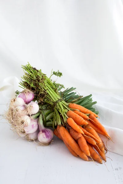 Лук и морковь на белом фоне стола и ткани — стоковое фото