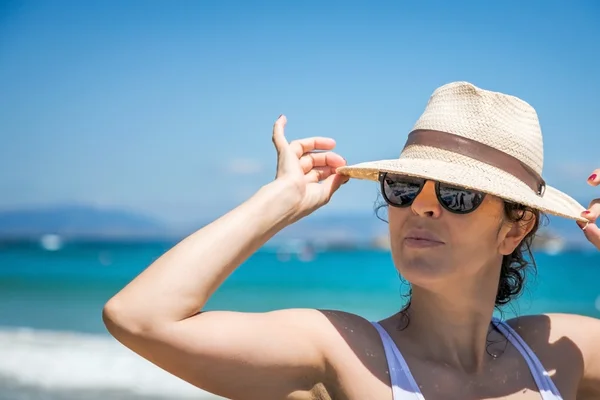 Hübsche Frau mit Hut am Strand — Stockfoto