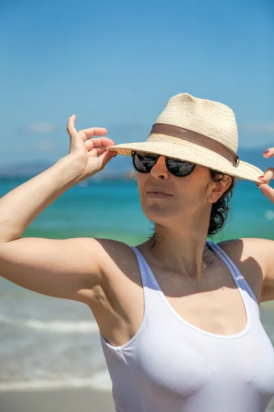 Hübsche Frau mit Hut und Sonnenbrille am Strand — Stockfoto