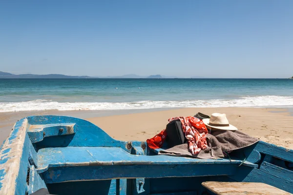 Hut und Handtuch auf dem Boot am Strand — Stockfoto