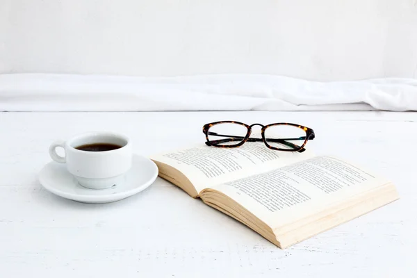 Βιβλίο με γυαλιά για το λευκό ξύλινο τραπέζι — Φωτογραφία Αρχείου