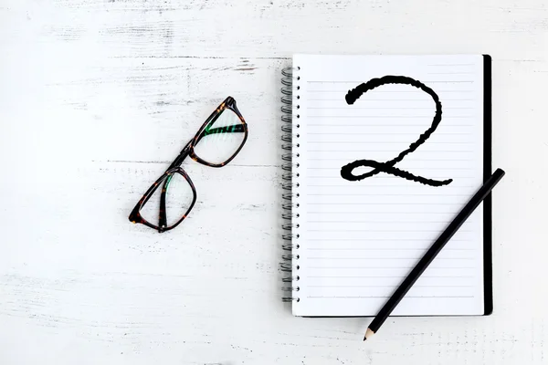 Cuaderno con lápiz sobre madera la palabra escrita con dos — Foto de Stock