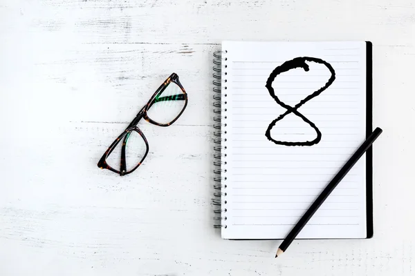 Cuaderno con lápiz sobre madera con la palabra escrita ocho — Foto de Stock