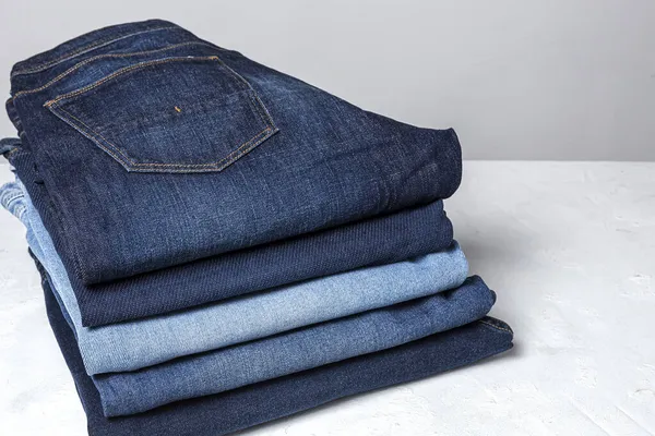 青いジーンズのパンツの服の背景杭 素敵なブルージーンズの詳細 — ストック写真