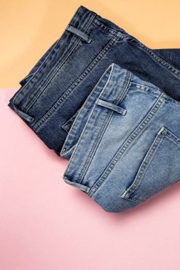 Renkli arka planda mavi kot pantolon izole edilmiş. Denim moda ayrıntıları