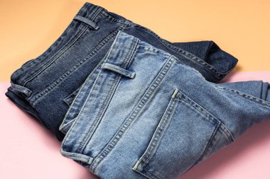 Renkli arka planda mavi kot pantolon izole edilmiş. Denim moda ayrıntıları