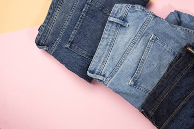 Renkli arka planda mavi kot pantolon izole edilmiş. Denim moda ayrıntıları
