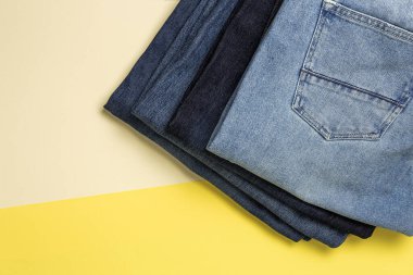 Renkli arka planda mavi kot pantolon izole edilmiş. Denim moda ayrıntıları