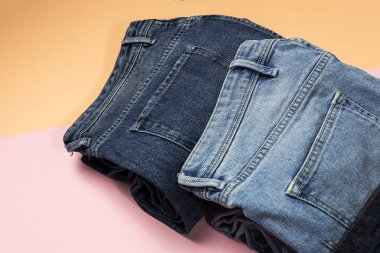 Renkli arka planda mavi kot pantolon izole edilmiş. Denim moda ayrıntıları