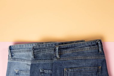 Renkli arka planda mavi kot pantolon izole edilmiş. Denim moda ayrıntıları