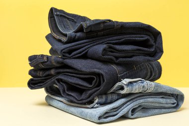 Renkli arka planda mavi kot pantolon izole edilmiş. Denim moda ayrıntıları