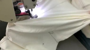Endüstriyel giyim fabrikasındaki dikiş makinesinde kot pantolon yapma süreci. Tekstil konsepti. Video
