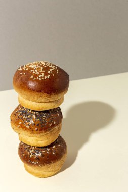 Renkli bir arka planda tohum ve yüksek kontrastlı ışıkla çeşitli ev yapımı çörekler.