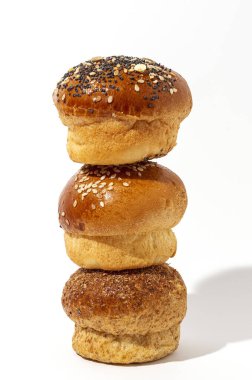 Yüksek kontrastlı ışıkla beyaz arka planda tohumlu ev yapımı brioche çörekleri. İzole edilmiş