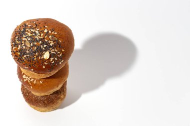 Yüksek kontrastlı ışıkla beyaz arka planda tohumlu ev yapımı brioche çörekleri. İzole edilmiş