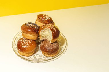 Renkli bir arka planda tohum ve yüksek kontrastlı ışıkla çeşitli ev yapımı çörekler.