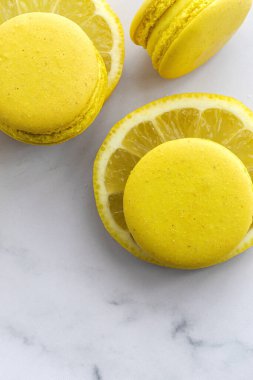 Limonlu ev yapımı sarı badem kurabiyeleri mermer zemine yakın.