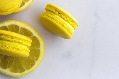 Limonlu ev yapımı sarı badem kurabiyeleri mermer zemine yakın.