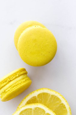 Limonlu ev yapımı sarı badem kurabiyeleri mermer zemine yakın.