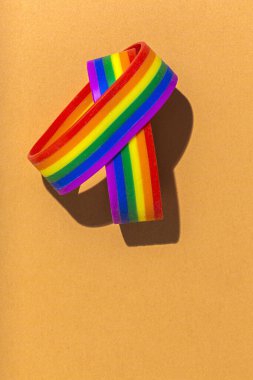 Renkli arkaplanda gökkuşağı renkleri olan LGBT bilezikleri