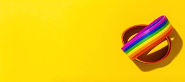 Renkli arkaplanda gökkuşağı renkleri olan LGBT bilezikleri