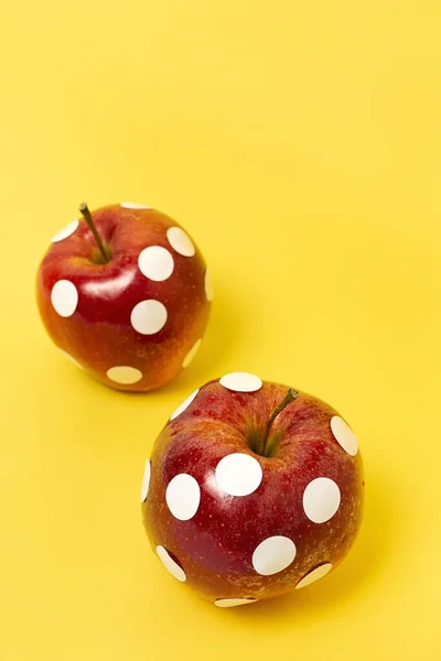 Red apples with white polka dots on colorful background. isolated