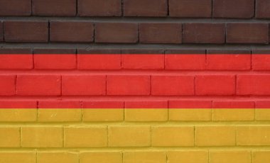 Alman bayrağı kırmızı siyah ve altınla tuğla bir duvara boyanmış.