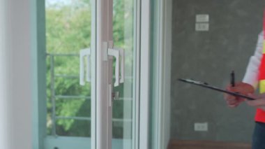 Müfettiş Mühendis, kurulumdan sonra kapının denetleme cihazıdır. Müteahhit, müşteriye teslim edilmeden önce cam kapının kilidini test ediyor. Bir mühendis tarafından ev teftişi kavramı.