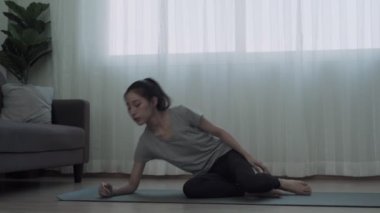 Sağlıklı kadınlar evde yoga yaparak egzersiz yaparlar. Kadınlar bacaklarını yukarı aşağı hareket ettirmek için bacaklarını kaldırarak yoga yapıyorlar. güçlendirme ve gevşeme için konsept yoga.