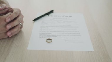 Boşanma belgesinin arasında evlilik yüzüğünü çıkar. Sevgili kavramlarının ailevi sorunları ve boşanmaları veya tartışmaları veya anlaşmazlıkları