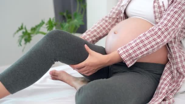妊娠中の女性は痛みを軽減するために自分の足やマッサージにけいれんを持っています けいれんは妊娠中の女性の一般的な症状です 妊娠中の女性の概念症状 — ストック動画