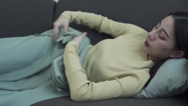 Covid19の症状監視の概念 熱で寒さを感じるアジア人女性が毛布に包まれる デジタル温度計で熱を感じる女性 — ストック動画
